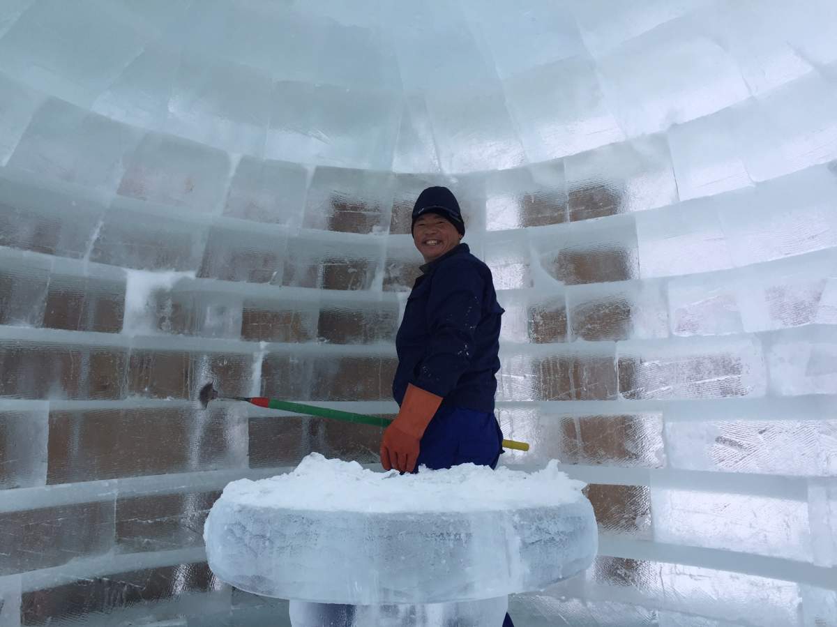 One of the 40 artists who flew here from China works  on his sculpture for Icetival.