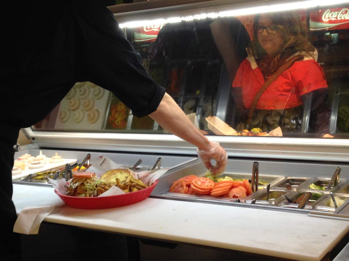 A worker at Habaneros in Dartmouth serves up tacos to a customer.