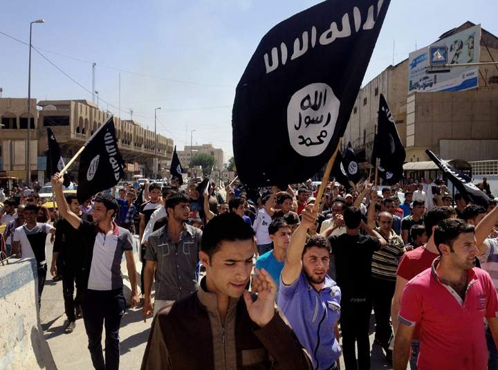 FILE - In this June 16, 2014 file photo, demonstrators chant pro-Islamic State group slogans as they carry the group's flags in front of the provincial government headquarters in Mosul, Iraq. Despite the atrocities that made it notorious, the Islamic State group depicts itself as bringing a reign of justice and equality for Muslims under its radical version of Shariah law. But Syrians who have escaped its rule say public disillusionment is growing with jihadi fighters who have become an elite class. 