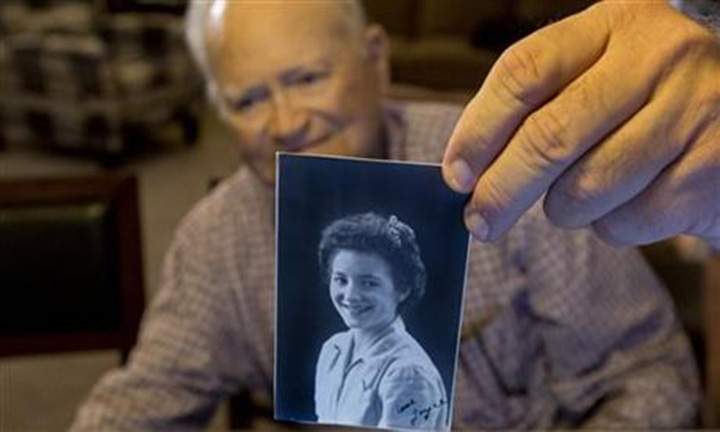 In this photo taken Nov. 6, 2015, Norwood Thomas, 93, holds up a photo of with Joyce Morris at his home in Virginia Beach, Va.