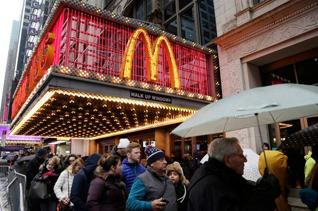 pedestrians pass under a McDonald's marquee in New York.