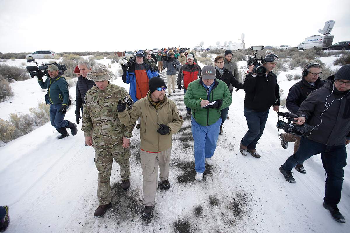Members of the group occupying the Malheur National Wildlife Refuge headquarters, left, conduct a tour with the media Monday, Jan. 4, 2016, near Burns, Ore.