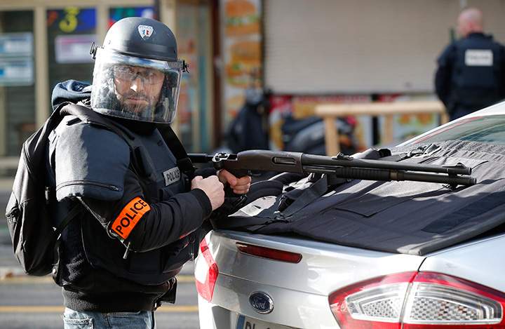 A police officer takes position after a fatal shooting at a police station in Paris, Thursday, Jan. 7, 2016.