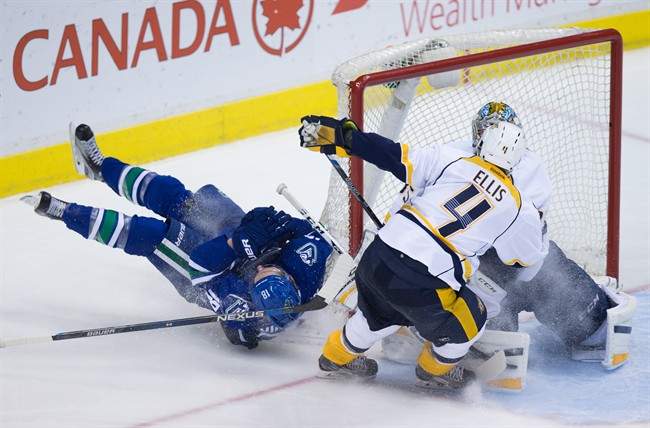Vancouver Canucks' Jake Virtanen, left, crashes into the net after a scoring chance on Nashville Predators' goalie Pekka Rinne, back right, of Finland, as Ryan Ellis (4) defends during third period NHL hockey action, in Vancouver on Tuesday, Jan. 26, 2016.