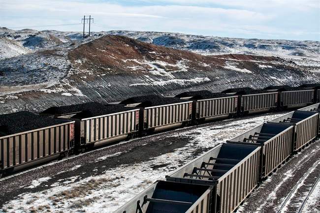 FILE - In this Jan. 9, 2014, file photo, rail cars are filled with coal and sprayed with a topper agent to suppress dust at Cloud Peak Energy's Antelope Mine north of Douglas, Wyo.