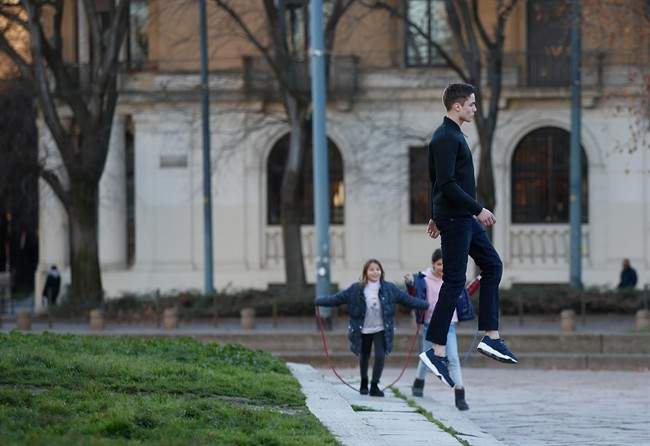 A model jumps during a photo shooting, in Milan, Italy, Friday, Jan. 15, 2016. Men's fashion week starts today and will run until Tuesday, Jan. 19.