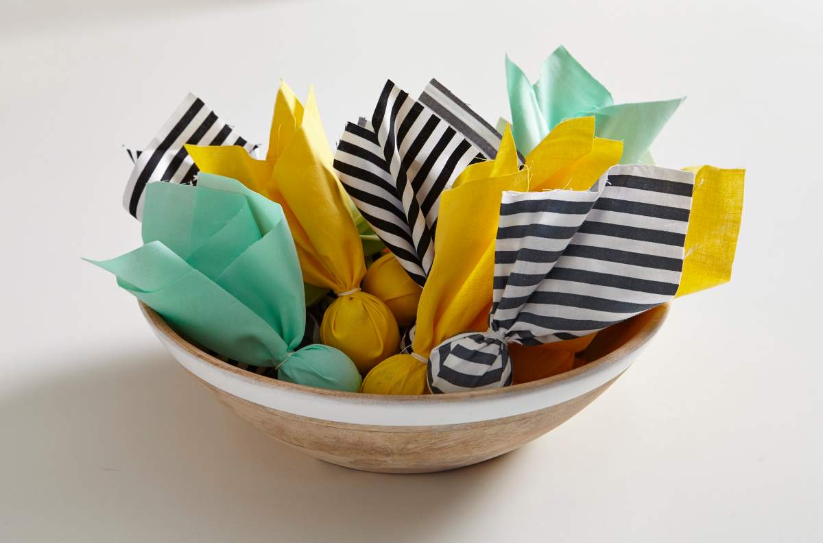 In this photo provided by Better Homes and Gardens, punch up the Super Bowl party fun with a few handmade decorations, including penalty flags made by wrapping a pingpong ball inside a 10-inch fabric square or heavy paper napkin and securing with a rubber band. Use this year’s Super Bowl colors — Denver Broncos orange and Carolina Panthers blue — and display an armload of penalty flags in a basket near the TV.