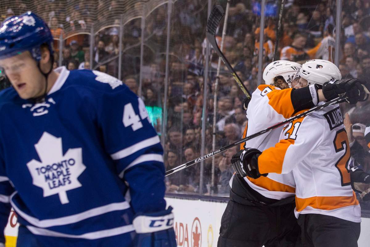 Philadelphia Flyers' Jacob Voracek, centre, celebrates with teammate Scott Laughton after scoring his team's second goal as Toronto Maple Leafs' Morgan Reilly skates by during first period NHL hockey action, in Toronto on Saturday, Feb. 20, 2016. 