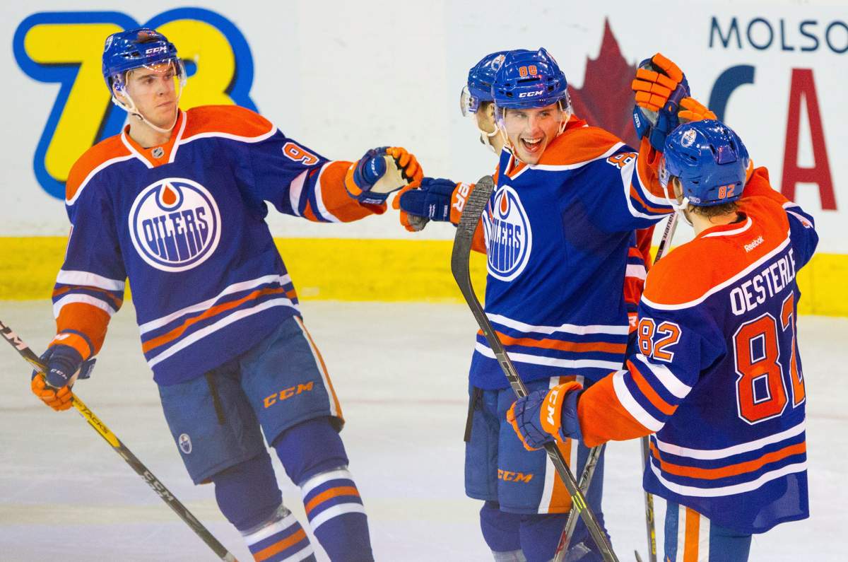 Edmonton Oilers' Brandon Davidson (88) celebrates his goal on the New York Islanders with teammates Connor McDavid (97), left to right, Jordan Eberle (14) and Jordan Oesterle (82) during third period NHL hockey action, in Edmonton, Alta., on Sunday, Feb. 28, 2016. The Oilers won 3-1. 