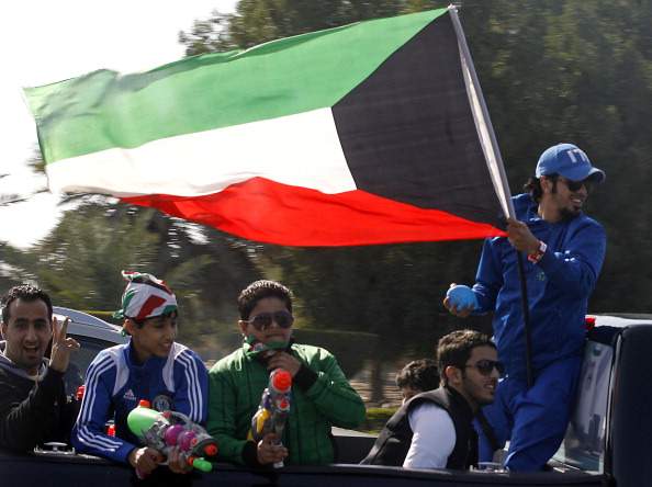 A Kuwaiti man waves his national flag as people drive through a street during celebrations marking the Gulf state's 51st Independence Day and the 21st anniversary of the end of the Gulf war with the liberation of Kuwait from Iraqi occupation, in Kuwait City on February 26, 2012.