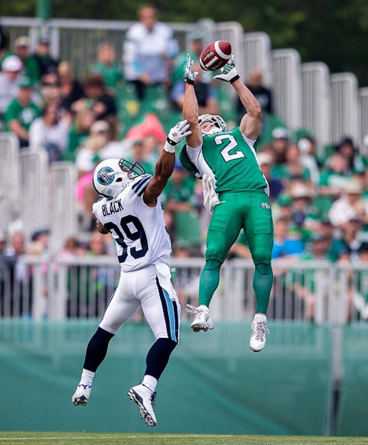 Ryan Smith of the Saskatchewan Roughriders goes up to make a spectacular catch in front of Toronto Argonauts Matt Black during a game in Regina, Saskatchewan on July 5, 2015.