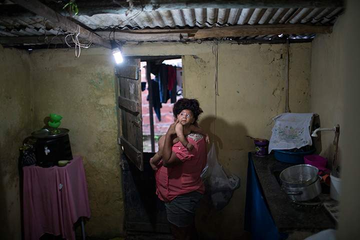 In this Jan. 30, 2016 photo, Solange Ferreira carries her son Jose Wesley at their house in Bonito, Pernambuco state, Brazil.
