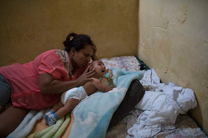 In this Jan. 30, 2016 photo, Solange Ferreira tries to make her son Jose Wesley sleep, in Bonito, Pernambuco state, Brazil.