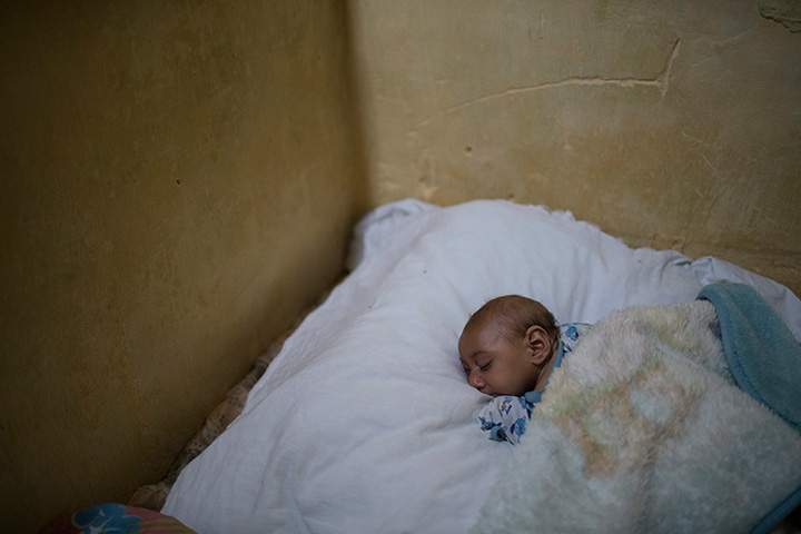 In this Jan. 30, 2016 photo, Jose Wesley sleeps over a large pillow on his mother’s bead in Bonito, Pernambuco state, Brazil.