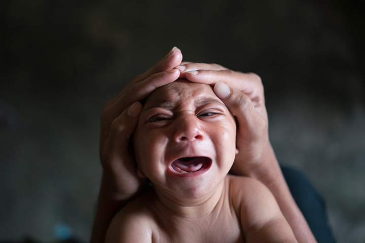 In this Jan. 30, 2016 photo, Elielson tries to calm down his baby brother Jose Wesley, in Bonito, Pernambuco state, Brazil. 