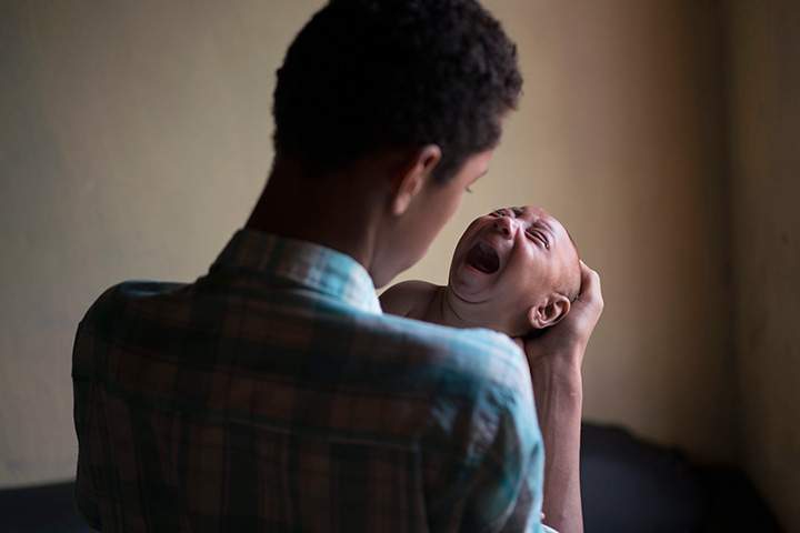 In this Jan. 30, 2016 photo, Elielson tries to calm down his baby brother Jose Wesley, in Bonito, Pernambuco state, Brazil.