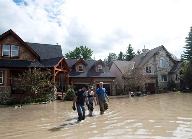 Residents walk through flood waters in Calgary on June 24, 2013. Storms