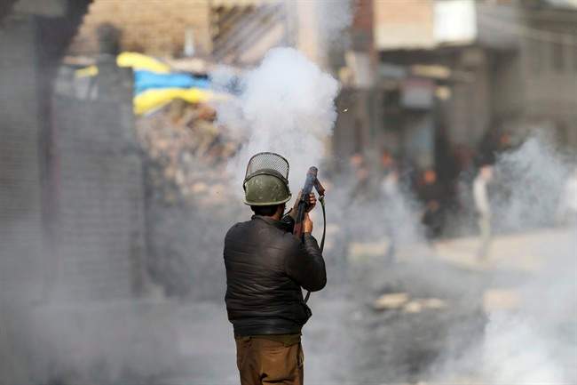 An Indian policeman fires tear smoke shell on protesters during a clash in Srinagar, Indian controlled Kashmir, Monday, Feb. 15, 2016. 