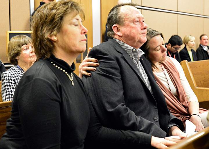 Michelle Wilkins, right, hugs her father as a verdict is read in Dynel Lane's trial, Tuesday, Feb. 23, 2016, in Boulder, Colo. The jury found Lane guilty of attempted first-degree murder, assault and unlawful termination of a pregnancy in last year's attack. 