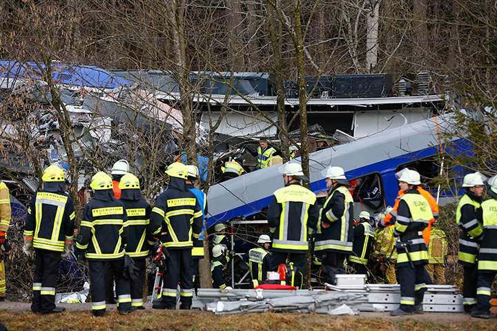 Rescue personnel stand in front of two trains that collided head-on near Bad Aibling, southern Germany, on Tuesday, Feb. 9, 2016.