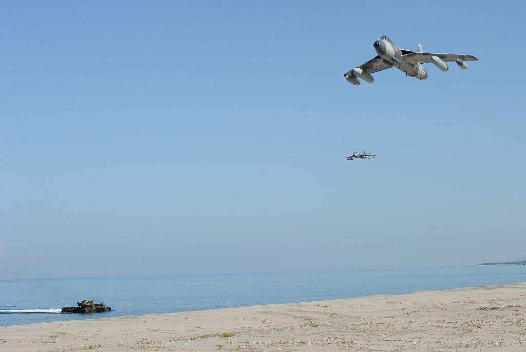 US Marine MK-58 Hawker Hunter fighter jets (R)  fly over an assault amphibious vehicle (AAV) during an amphibious landing exercise as part of annual joint US-Philippines naval exercises facing the South China Sea at a naval training center in San Marcelino, north of Manila on October 9, 2015. 