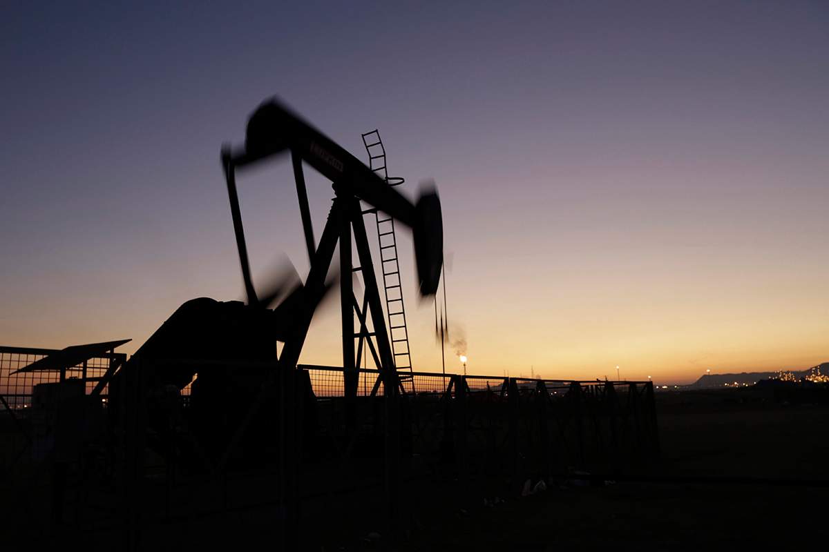 An oil pump works at sunset.