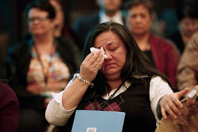 A woman wipes away a tear around a sharing circle at the 2nd National Roundtable on Missing and Murdered Indigenous Women and Girls in Winnipeg on Thursday, Feb. 25, 2016.