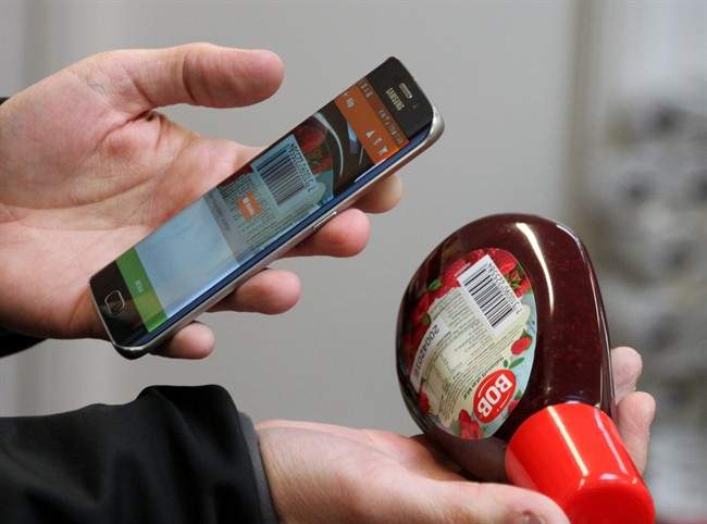 Swedish IT entrepreneur Robert Ilijason shows how to use a cell phone to scan a purchase at the no-staff, app shop in the southern Sweden village of Viken in this photo dated Jan. 27, 2016.