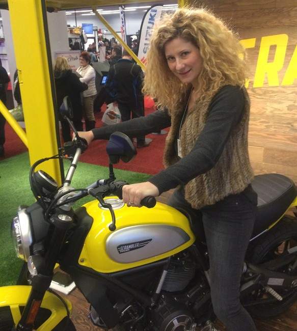Bianca Kennedy, show manager for the Montreal motorcycle show, poses for a photo on her Ducati Scrambler, in Montreal on Sunday, Feb. 28, 2016.
