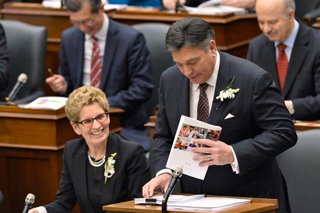 Ontario Finance Minister Charles Sousa, right, delivers the Ontario 2016 budget next to Premier Kathleen Wynne, left, at Queen's Park in Toronto on Thursday, February 25, 2016. 