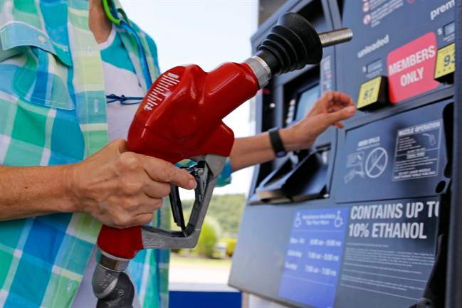 FILE - In this Thursday, July 16, 2015, file photo, a customer re-fuels her car at a Costco in Robinson Township, Pa. 