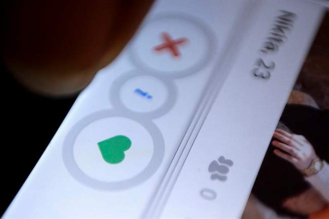 In this July 5, 2015, file photo, a man uses the dating app Tinder.