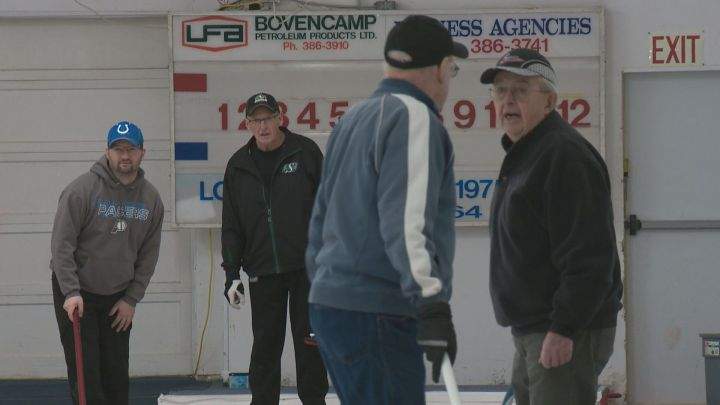 Don Cookson (second from right) and Don Manning (far right) discuss strategy during a curling match against Cookson’s grandson on Feb. 3, 2016.