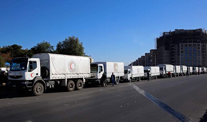 A convoy of humanitarian aid waits in front of the United Nations Relief and Works Agency offices before making their way into the government besieged rebel-held towns of Madaya, al-Zabadani and al-Moadhamiya in the Damascus countryside, as part of a U.N.-sponsored aid operation in Syria, Wednesday, Feb. 17,  2016.