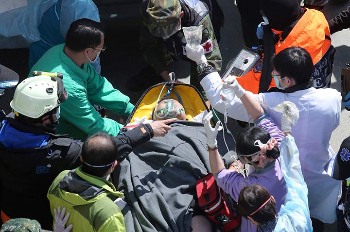 Emergency rescue workers attend survivor Lee Tsung-tien after being rescued from the rubble of a collapsed building complex in Tainan, Taiwan, Monday, Feb. 8, 2016. 