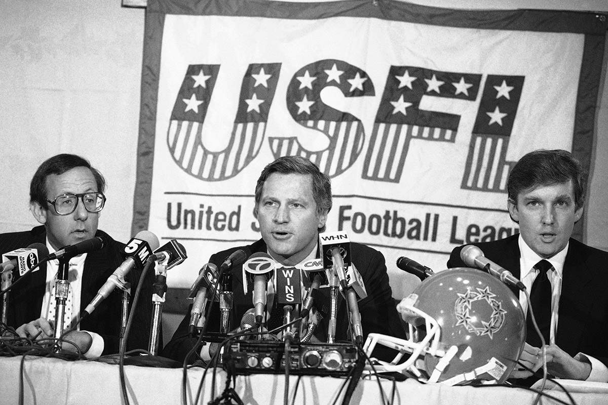 In this Aug. 2, 1985, file photo, Donald Trump, right, New York real estate magnates Stephen Ross, left, and USFL Commissioner Harry L. Usher, center, participate in a news conference in New York to discuss the agreement they have reached in principle to merge the Houston Gamblers and New Jersey Generals football franchises. The New Jersey Generals have been largely forgotten, but Trump’s ownership of the team was formative in his evolution as a public figure and peerless self-publicist. With money and swagger, he led a shaky and relatively low-budget spring football league, the USFL, into a showdown with the NFL.
