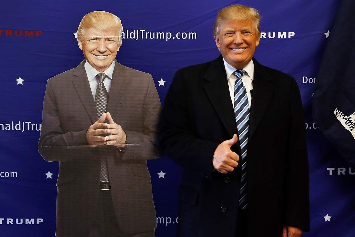 Republican presidential candidate Donald Trump poses with a cutout while visiting his campaign office, Tuesday, Feb. 16, 2016, in Greenville, S.C.