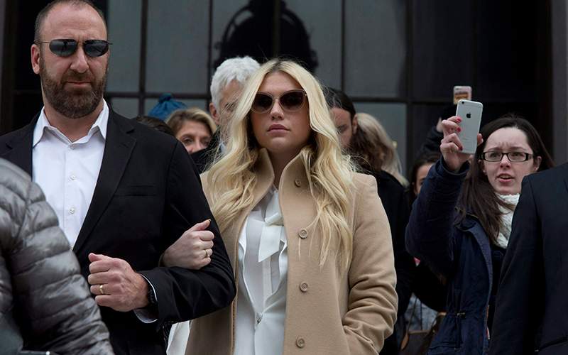 Pop star Kesha, center, leaves Supreme court in New York, Friday, Feb. 19, 2016. Kesha is fighting to wrest her career away from a hitmaker she says drugged, sexually abused and psychologically tormented her - and still has exclusive rights to make records with her. 