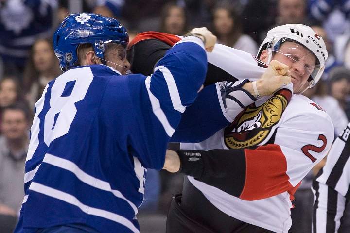 Toronto Maple Leafs’ Colin Greening, left, fights with Ottawa Senators’ Dion Phaneuf during first period NHL hockey action in Toronto on Saturday March 5, 2016.