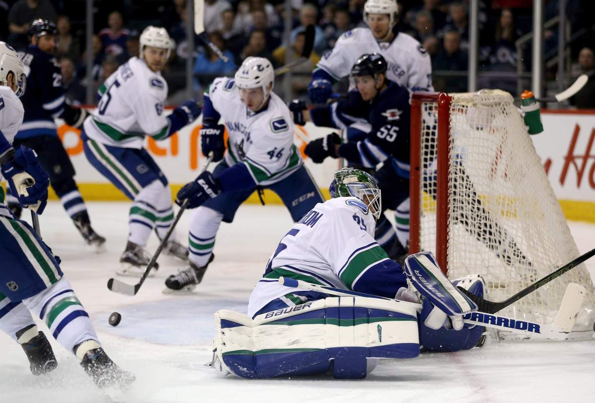 Vancouver Canucks' goalie Jacob Markstrom (25) is out of position after stopping Winnipeg Jets' Nic Petan, not pictured, at the side of the net during second period NHL hockey action in Winnipeg, Tuesday, March 22, 2016. 