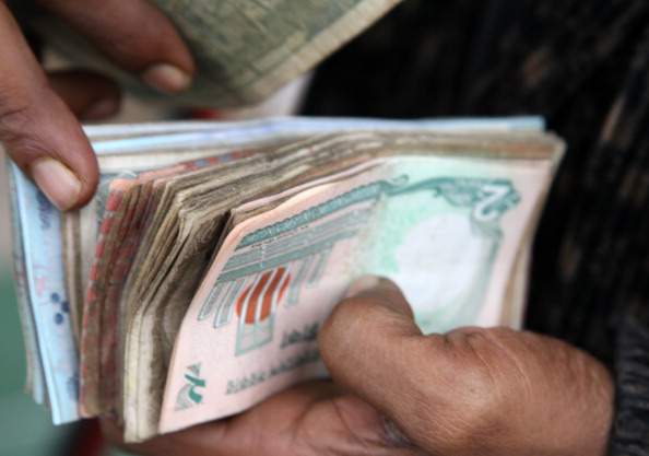 A vender counts bank notes at a market in Dhaka, Bangladesh, on Monday, Jan. 9, 2012. 