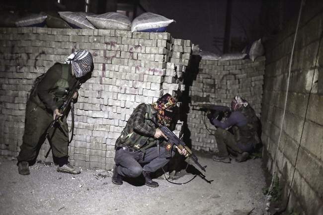 In this photo dated Thursday Feb. 25, 2016, militants of Kurdistan Workers' Party, PKK, move to attack Turkish security forces in Nusaybin, south Turkey, Thursday, Feb. 25, 2016.