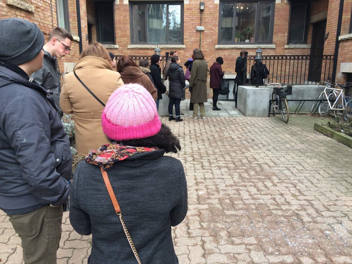 Graham Post and Alexis Gabrielle stand in a long line, waiting to view a Toronto apartment rental.