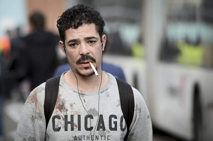 A man with blood stains on his sweater leaves Brussels airport in Zaventem on March 22, 2016 following twin blasts. 