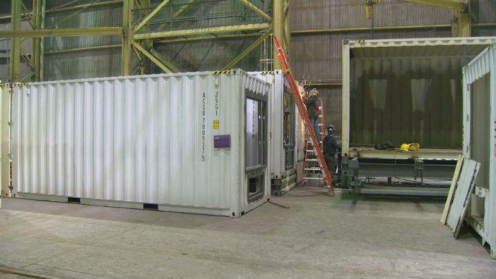 Workers at Calgary-based Ladacor Advanced Modular Systems work on an old shipping container that will be turned into one of 63 suites in a new hotel.