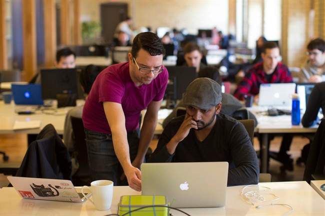 A tutor helps a student at Lighthouse Labs, which offers bootcamps on coding, in Toronto on Thursday, March 17, 2016.