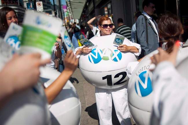 Janine Lubey, centre, promotes the Lotto-Max lottery at Yonge and Dundas Square in Toronto on September 25, 2015. 