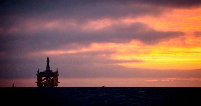 In this April 17, 2015 file photo, an oil drilling rig arrives aboard a transport ship at sunrise, following a journey across the Pacific in Port Angeles, Wash. 