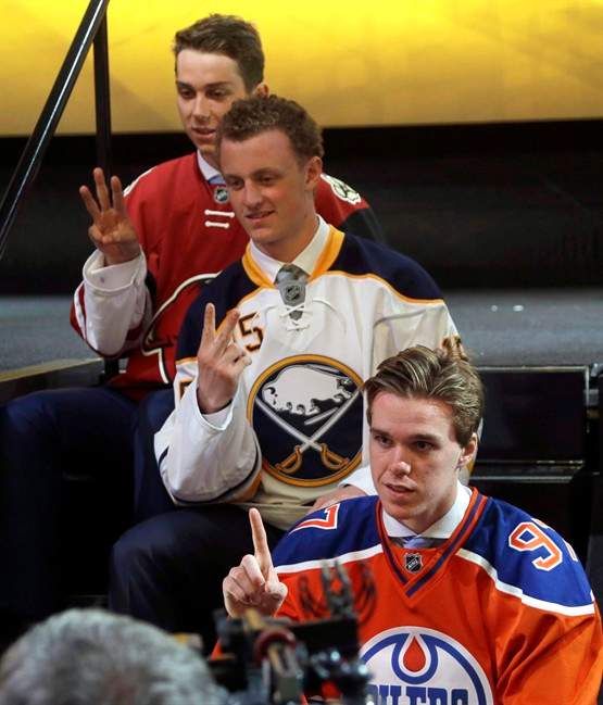 Connor McDavid, foreground, first overall pick; Jack Eichel, center, second overall pick; and Dylan Strome, third overall pick; pose for cameras during the first round of the NHL hockey draft, Friday, June 26, 2015, in Sunrise, Fla. Linked together even before they were selected with the first two picks of the NHL Draft last June, McDavid and Eichel continue to travel a similar path.