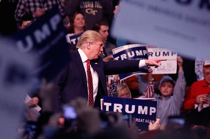 Republican presidential candidate Donald Trump points out a protester during a rally at Macomb Community College, Friday, March 4, 2016, in Warren, Mich. 